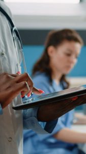 Close up of african american doctor using tablet with touch screen